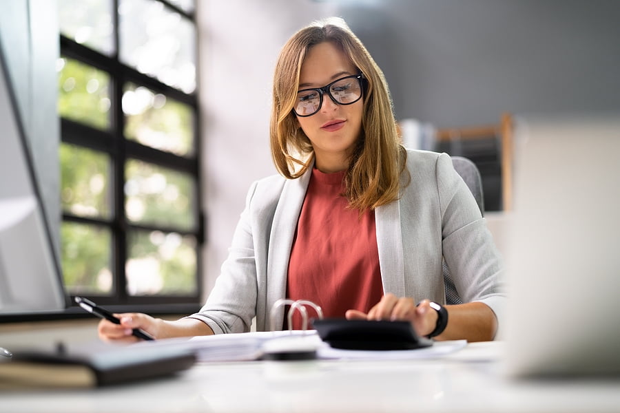 Woman on her desk computing for print orders at trade pricing